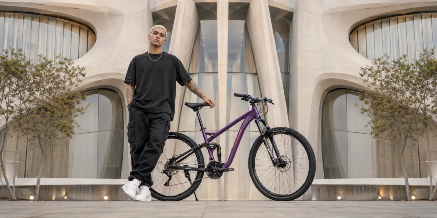 Rider standing next to a purple Rocatomic mountain bike